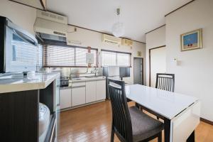 a kitchen with a table and chairs in a room at KEI HOUSE Yamato 202 in Yamato
