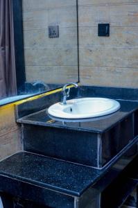a bathroom counter with a sink in a room at Henry George Hotel Ltd in Idimu