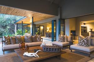 a living room with couches and a table at Ujima Lodge in Hoedspruit +57 photos