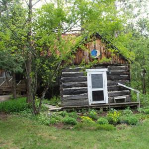an old log cabin with a window in a yard at The Barn - A Unique Gathering Place in Sainte-Cécile-de-Masham +63 photos