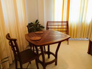 a wooden table and chairs in a room at Crystal Pearl Villa in Weligama