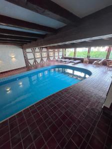 a large swimming pool with blue water in a building at Bed & Breakfast Schäfer in Enzklösterle