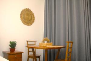 a table and chairs in a room with a curtain at Crystal Pearl Villa in Weligama +23 photos