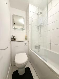 a bathroom with a toilet and a shower and a tub at Princess House in Redhill +9 photos