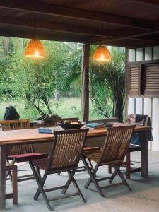 a wooden table with chairs and a large window at Casa Tassimirim in Ilha de Boipeba +22 photos