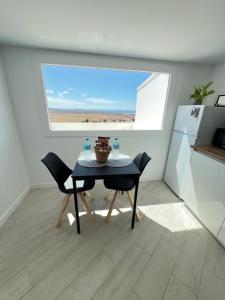 a table and chairs in a kitchen with a window at Gratitud Un refugio con encanto in Soo