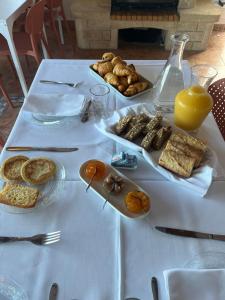 a white table with bread and other food on it at la maison CM in Nessa