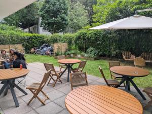 a patio with tables and chairs and an umbrella at Le Jourdain in Paris