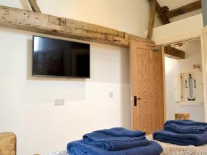 two blue towels sitting on a bed with a tv on the wall at Ey Up - Uk11447 in Skipsea