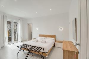 a white bedroom with a bed and a wooden table at B&B Santa Maria in Agerola
