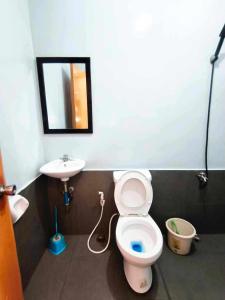 a bathroom with a toilet and a sink at Marias's Inn in Pooc