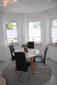 a dining room with a table and chairs and windows at Apartment Julia in Bad Orb