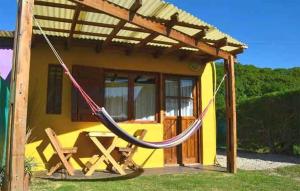 a hammock in front of a tiny house at Cabañas Alfar Sol y Mar in Mar del Plata