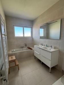 a bathroom with a sink and a tub and a mirror at Appartement Bassin d' Arcachon in La Teste-de-Buch +15 photos