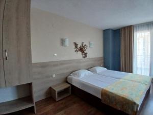 a bedroom with a large bed and a window at Zenith Guest House in Sozopol