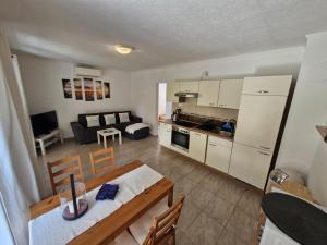 a kitchen and a living room with a table and chairs at Fenyves Ferienhaus 1 **** in Balatonfenyves