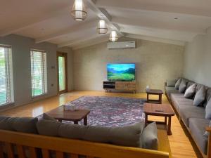 a living room with a couch and a flat screen tv at Oasis Rest ae in Madīnat an Nahḑah