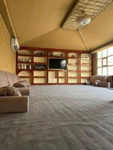 a large room with couches and a television in a room at Oasis Rest ae in Madīnat an Nahḑah +14 photos