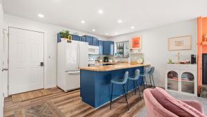 a kitchen with blue cabinets and blue stools at Daylight Cove Lakefront Chic in Lake Ozark