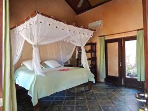 a bedroom with a bed with a canopy at Villa Sedeoen in Nembrala