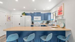 a kitchen with blue cabinets and blue chairs at Daylight Cove Lakefront Chic in Lake Ozark