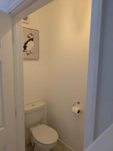 a bathroom with a toilet and a picture of a penguin at Fieldside View in Tydd Saint Giles