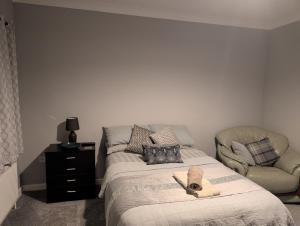 a bedroom with a bed and a chair with a hat on it at Fieldside View in Tydd Saint Giles
