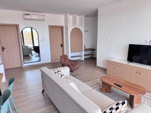 a living room with a couch and a tv at Keur Noflaye Ngaparou in Mbour