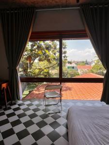 a chair in a bedroom with a checkered floor at Berry Boutique in Hue +71 photos