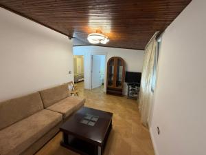 a living room with a couch and a table at Grand House Apartment in Selitë e Vogël