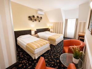 a hotel room with two beds and a chair at Hotel Cheap - Smart choice - Great value in Sofia