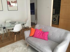a living room with a couch and a glass table at Casa Pedra do Sal in Estoril