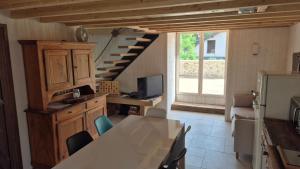a kitchen with a table and a desk and a staircase at La cabane du pédaleur in Fourbanne