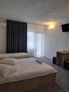 a hotel room with two beds and a window at Casa din Golful Dunării in Eşelniţa +30 photos