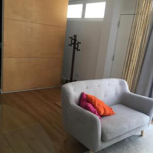 a gray couch with an orange pillow in a room at Casa Pedra do Sal in Estoril