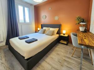a bedroom with a large bed and a wooden table at Le Tom de Libourne in Libourne +10 photos