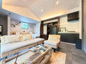 a bedroom with a bed and a living room at 奄美 Palm Tree Terrace in Ōkachi