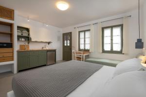 a bedroom with a large bed and a kitchen at Nissia Kamares in Kardamaina +122 photos