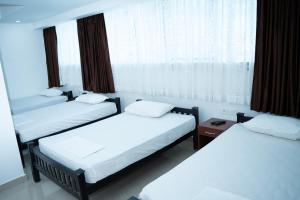 a room with three beds and a window at Hotel Idukki Castle in Idukki +20 photos
