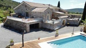 a large house with a swimming pool in front of it at Gîte Sud Ardèche in Vinezac