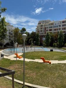 a park with a pool with orange benches and buildings at Cantinho Lusitano in Portimão