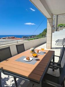 a wooden table on a balcony with a view of the ocean at Apartment Jakov i Lucija - Sea View Terrace & FREE PARKING in Dubrovnik