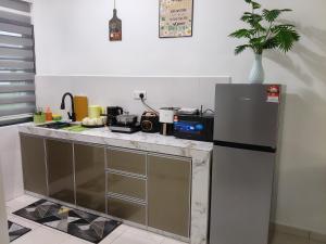 a kitchen with a counter with a refrigerator at Yashz Guest House in Port Dickson +3 photos