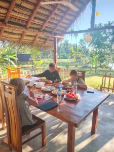 a group of children sitting at a wooden table at Jungle Lake View Cabana in Udawalawe