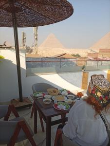 a table with food on it with a view of the pyramids at Basha Pyramids Best View in Giza