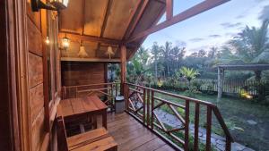 a wooden porch with a wooden bench on a balcony at Arsilahomestay in Tetebatu