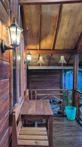 a wooden table on the porch of a cabin at Arsilahomestay in Tetebatu