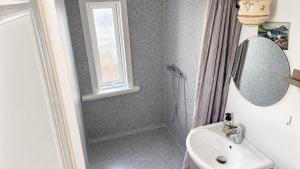 a bathroom with a sink and a mirror and a shower at Beachhouse Syðrugøta in Syðrugøta +15 photos