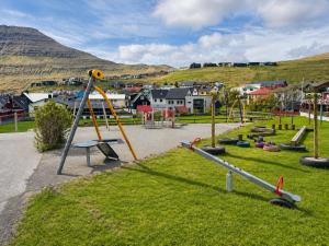 a park with a playground with a slide at Beachhouse Syðrugøta in Syðrugøta