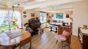 a living room with a table and a piano at Beachhouse Syðrugøta in Syðrugøta